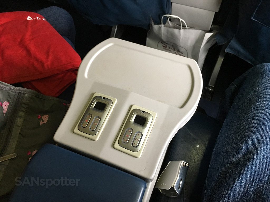 Delta Air Lines Aircraft Boeing 737-800 First Class center arm rest between the seats with basic audio controls and a large platform for beverages Photos @SANspotter
