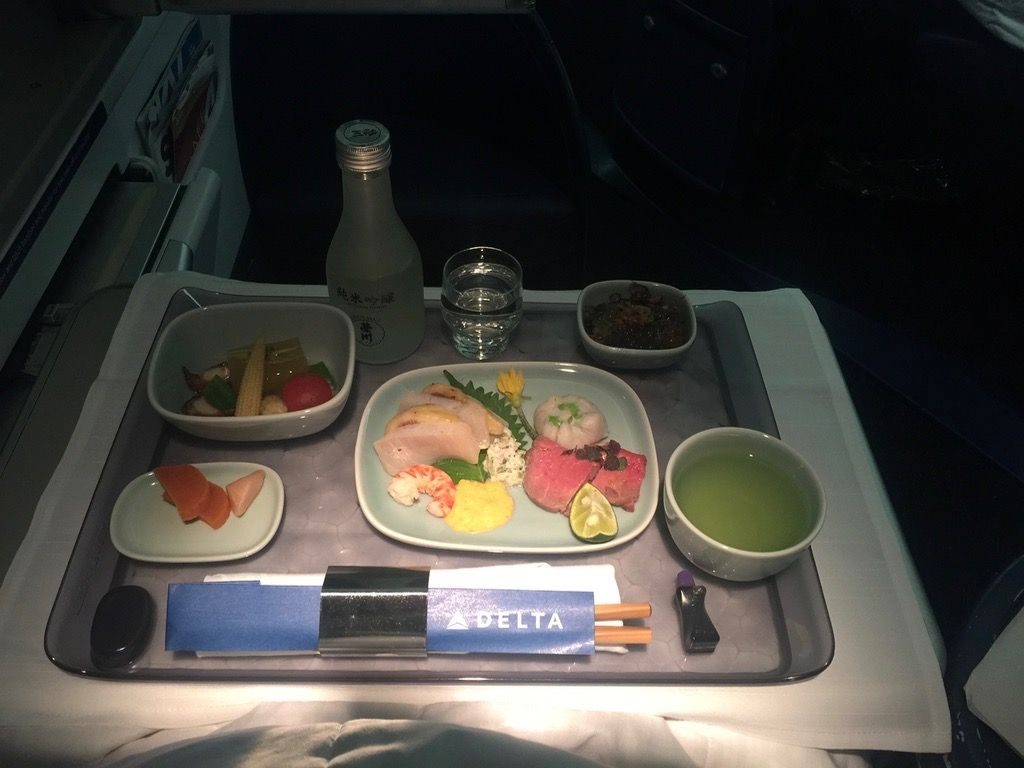 Delta Air Lines Fleet Boeing 777-200ER Business Elite Class (DELTA ONE) inflight food services Japanese meal starters are presented, along with some green tea and sake